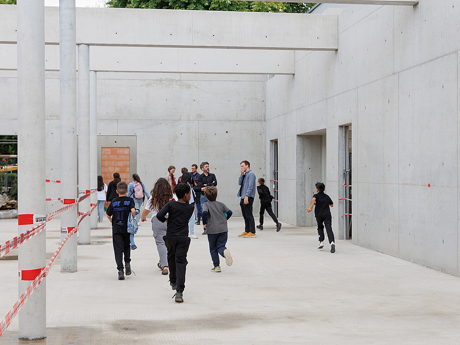 Kinder rennen in großer Betonhalle ohne Dach