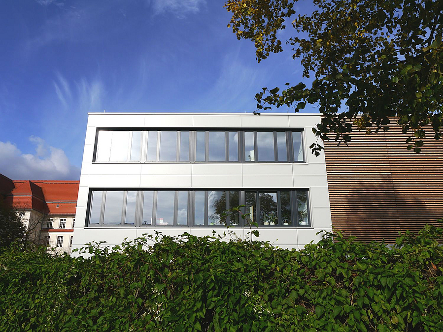 Modernes weißes Gebäude mit Fensterbändern und Lamellen