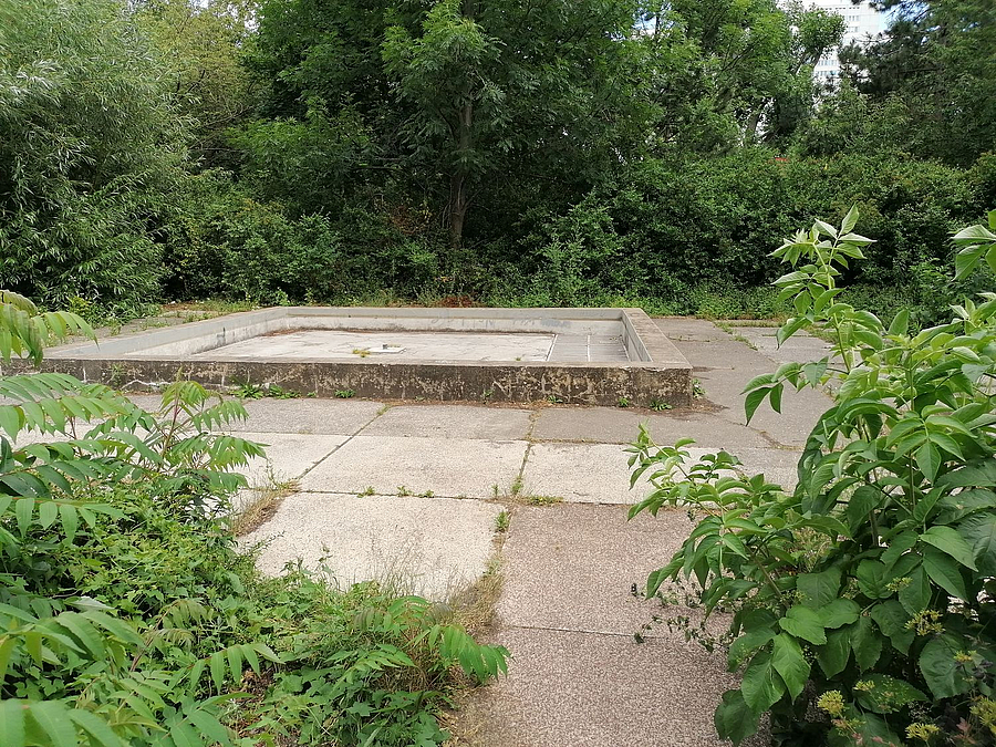 Zugang zu kleinem Brunnenplatz mit trockenem Becken