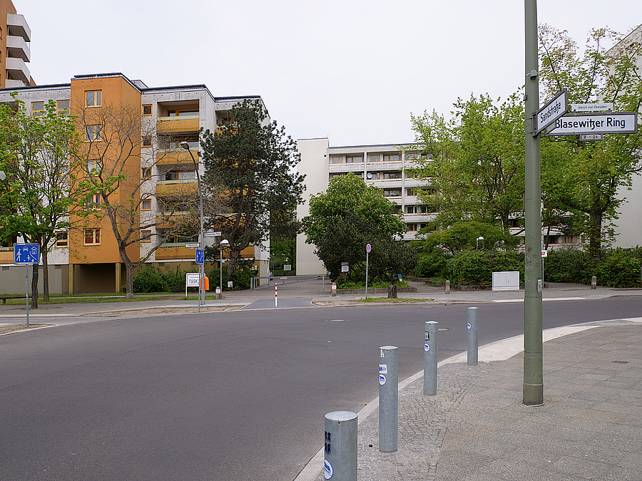 Straßenkurve und Einmündung Spielstraße vor Wohnhochhäusern, Poller