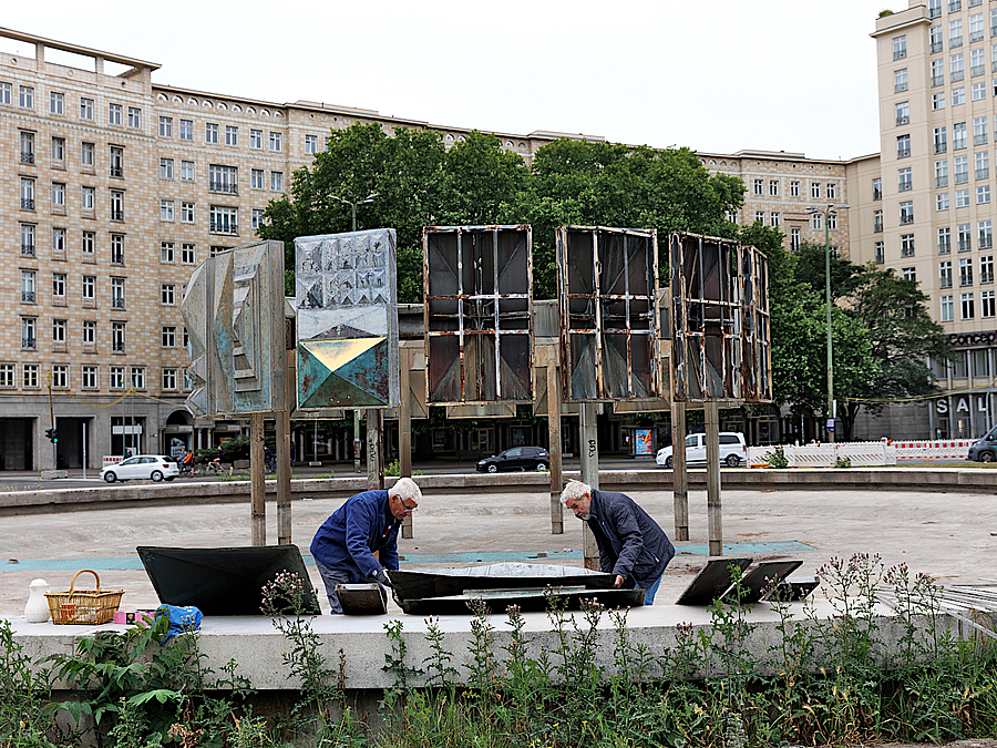 Arbeiter im Becken vor halb abgebauten Brunnenkunstwerk am Strausberger Platz