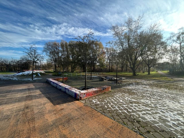 Parkanlage und maroder roter Asphaltboden im Winter